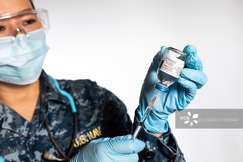 美国海军护士准备注射Covid - 19疫苗的注射器图片素材