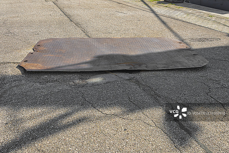 生锈的长方形钢板躺在街上图片素材