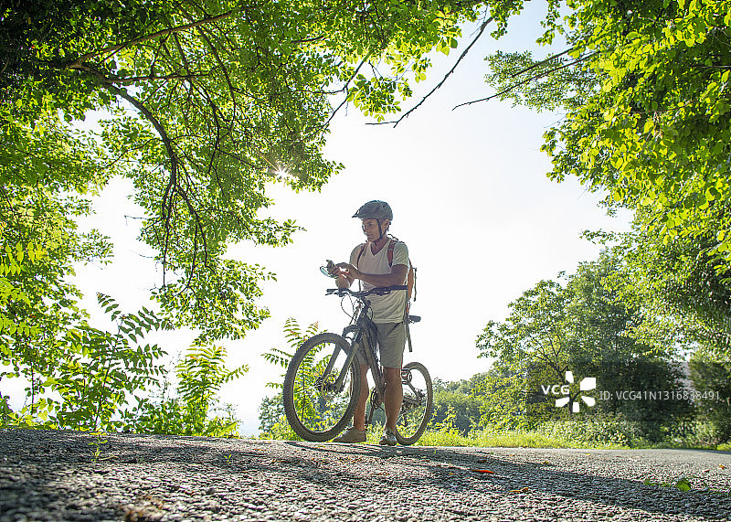 满人山地自行车穿过郁郁葱葱的森林图片素材