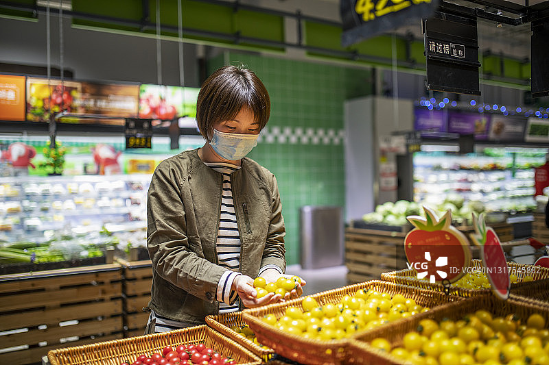 中年亚洲妇女在超市购买新鲜的有机食品。图片素材