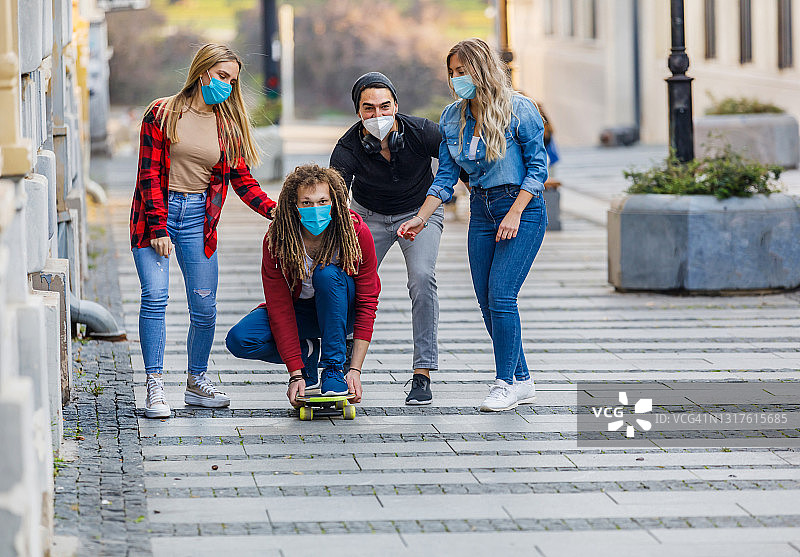 一小群朋友正在城市街道上玩滑板。图片素材