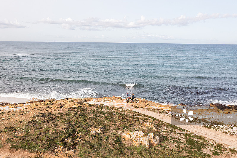 无人机拍摄的海岸线上骑自行车的人图片素材