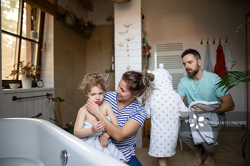 家庭带小孩在家里的浴室里，晾干后晚上洗澡。图片素材
