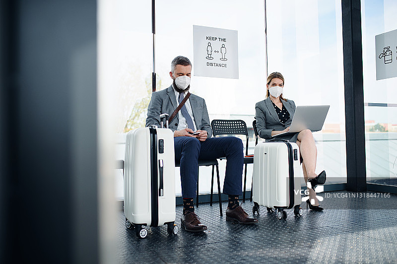 在机场候机室等候的男女、商务和冠状病毒概念。图片素材