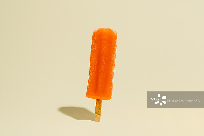 橙味和彩色冰棒棒在黄色的背景图片素材