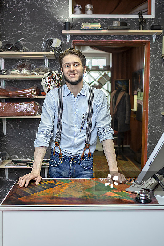 男手工艺人站在鞋店的桌子上图片素材