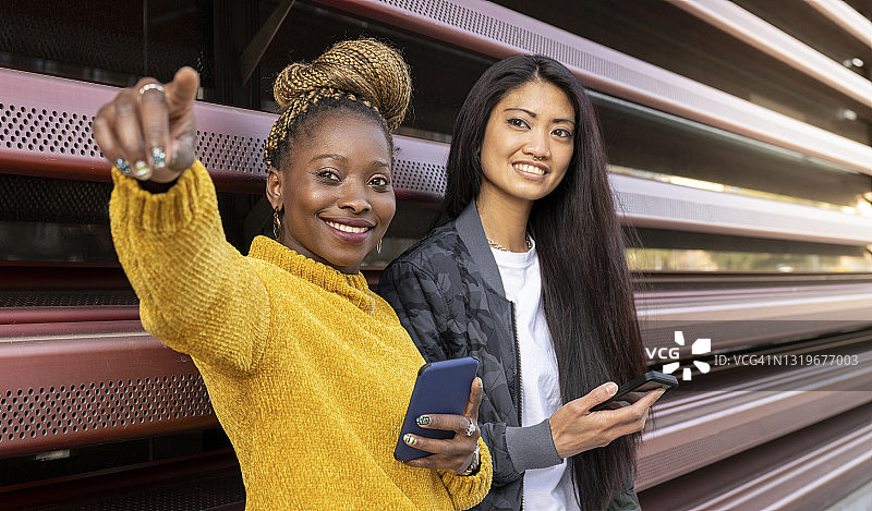 多种族的女性朋友在户外拿着智能手机图片素材