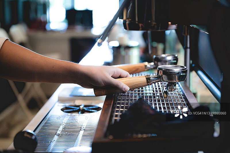咖啡馆里的浓缩咖啡机，专业的咖啡师在商店或餐厅的吧台用一杯咖啡制作热咖啡，现代咖啡店，棕色卡布奇诺饮料机图片素材