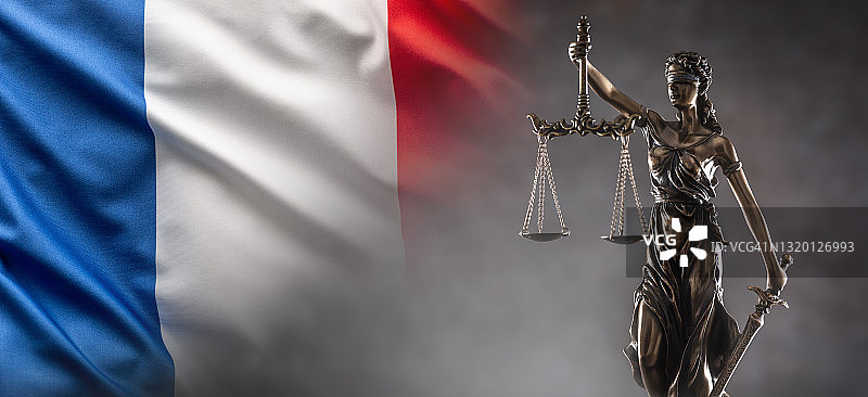 正义是一尊象征法律的盲人雕像，手中握着天平和剑，背景是一面法国国旗。图片素材