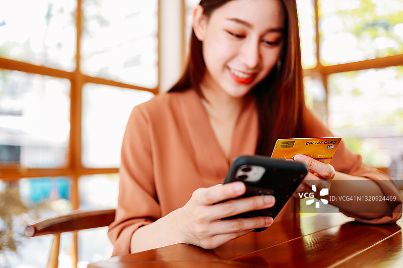 快乐的女性用手机刷卡付款图片素材