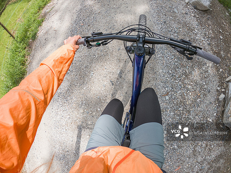 女性山地自行车手在夏季沿着小径骑行的视角图片素材