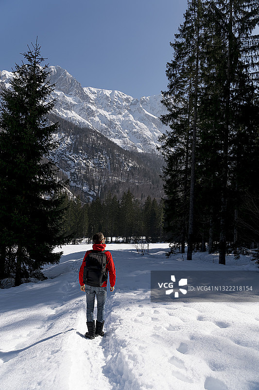 中年人背着背包在雪地里徒步旅行图片素材