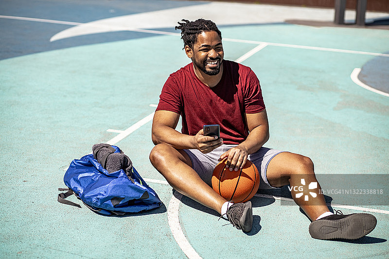 街头篮球运动员在球场上休息图片素材