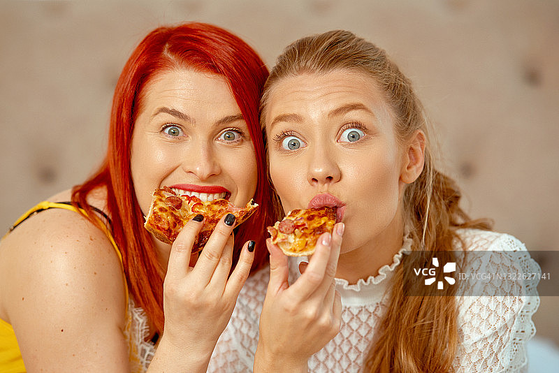 正面的金发和红发正在吃披萨图片素材