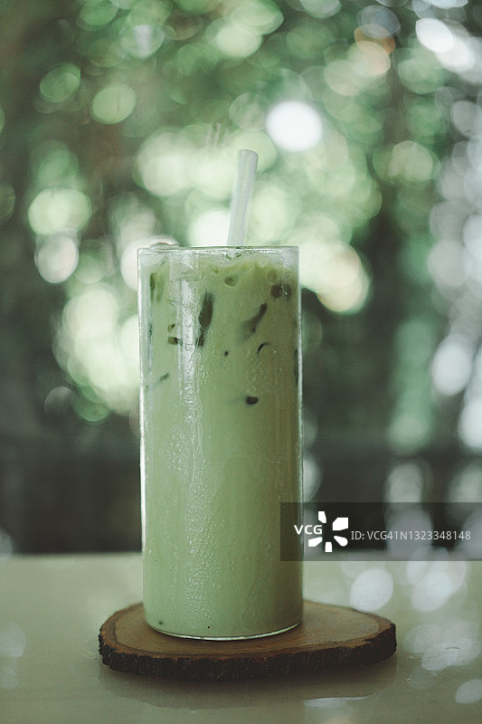 冰绿茶抹茶混合冰块和牛奶在高脚杯图片素材