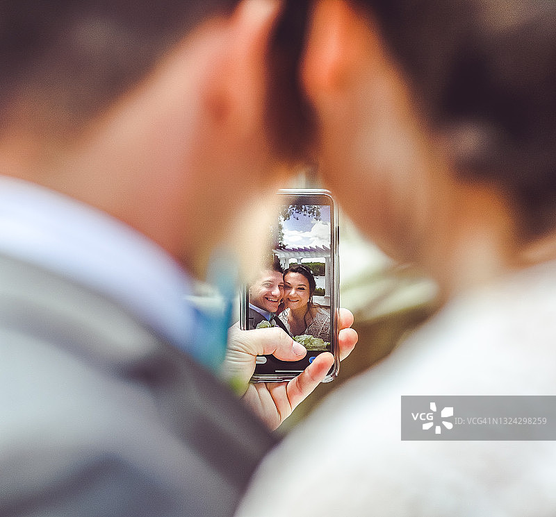 新娘和新郎在婚礼当天用手机自拍或视频通话图片素材