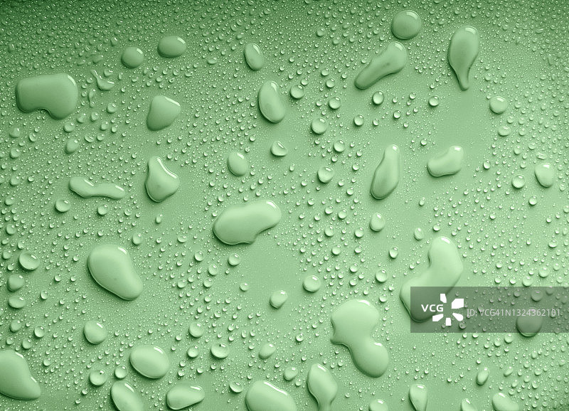 绿色背景上的水滴和水花的完整框架。图片素材