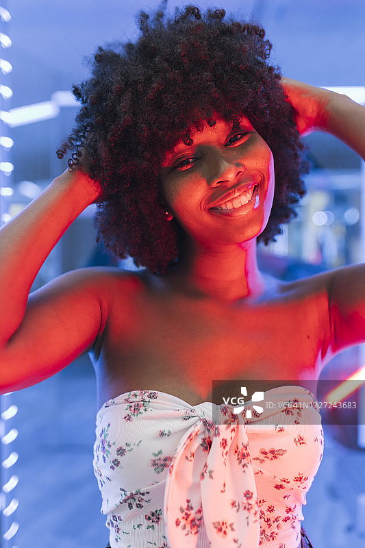 年轻的非洲裔妇女，头发在霓虹灯旁图片素材