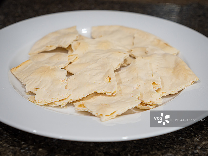 几片自制的未发酵面包(matzo)放在一个白色盘子上图片素材