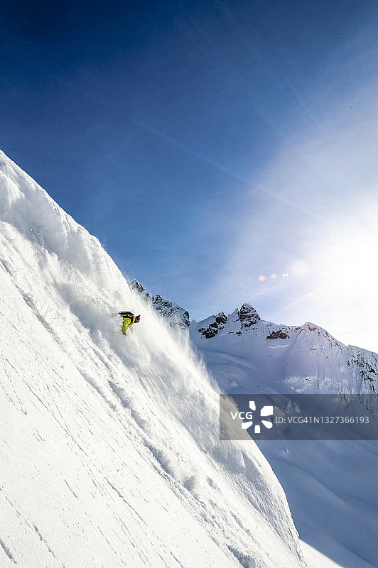 野外滑雪者从积雪的山脊上下来图片素材