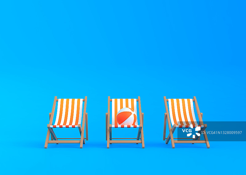 条纹躺椅和沙滩球在一个蓝色的背景图片素材