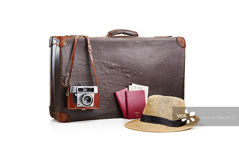 老式的老式棕色皮箱，配有一个胶卷照相机，一顶草帽和两本印有白色机票的护照图片素材