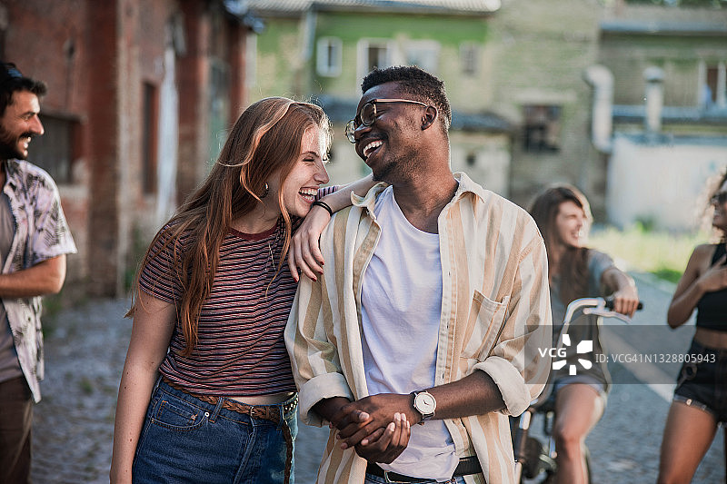 一对愉快的年轻夫妇在街上聊天。图片素材