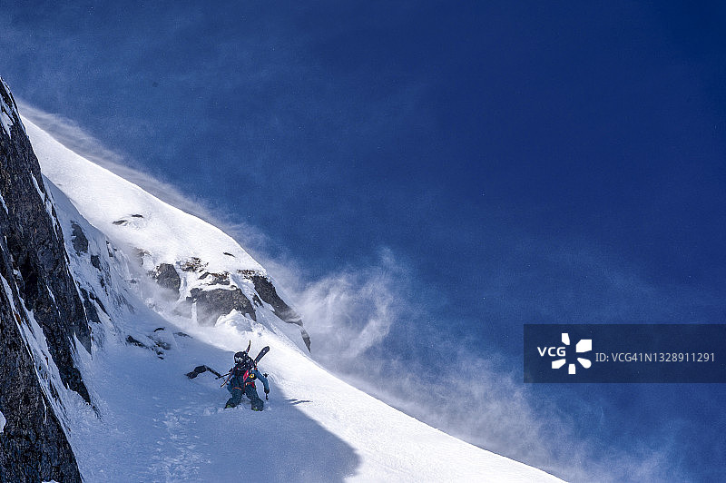 偏远地区的滑雪者攀登积雪的山坡图片素材