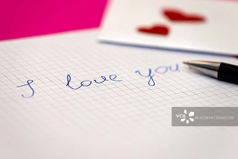 情书，钢笔和信封，粉红色背景上的小心形纸图片素材