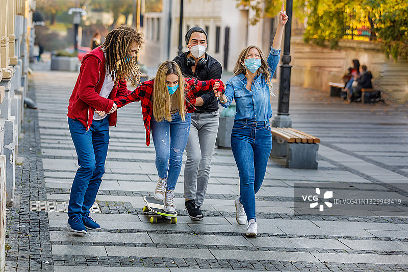 一群学生玩得很开心，他们在城市里玩滑板。图片素材