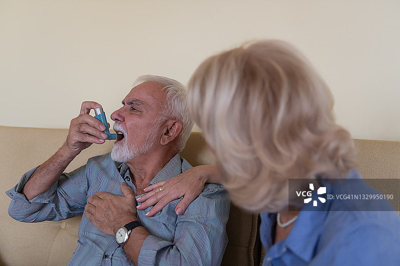 一张生病的老人在家与他的细心的妻子哮喘问题的照片。图片素材