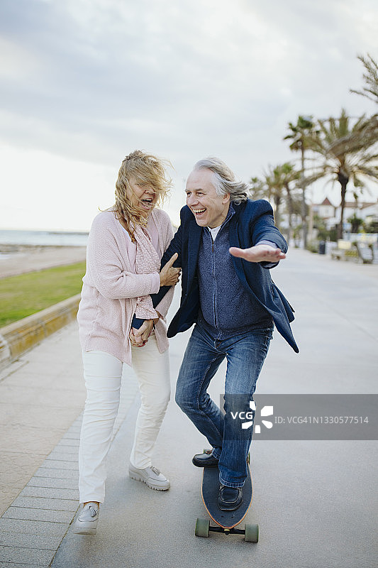 成熟的男人喜欢女人牵着手玩滑板图片素材
