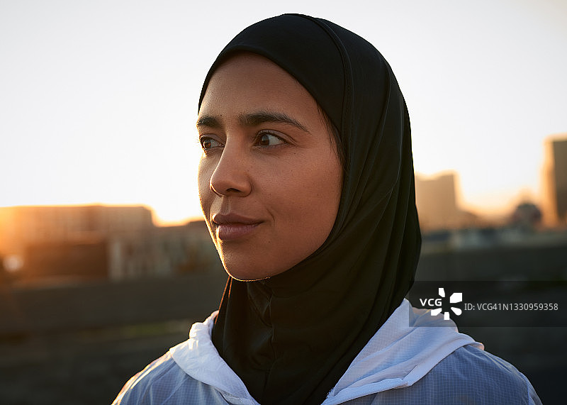 一名迷人的穆斯林女子在晨跑前独自站在城市里图片素材