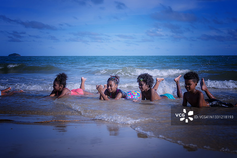 一群非洲裔美国孩子在海滩上玩耍。图片素材