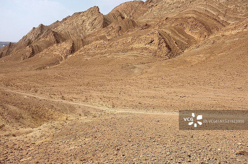 内盖夫沙漠的一条徒步路线，位于拉蒙火山口的底部，有山峰和岩层图片素材