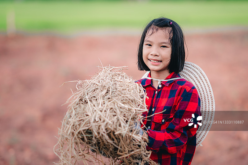 农村农场有机菜园里，孩子们拿着稻草种树图片素材