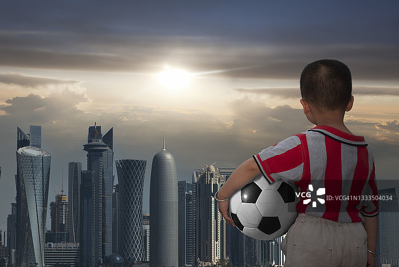 男孩带着足球观看现代都市图片素材