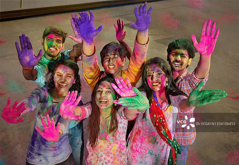 一群快乐的朋友在镜头前展示着充满色彩的双手图片素材