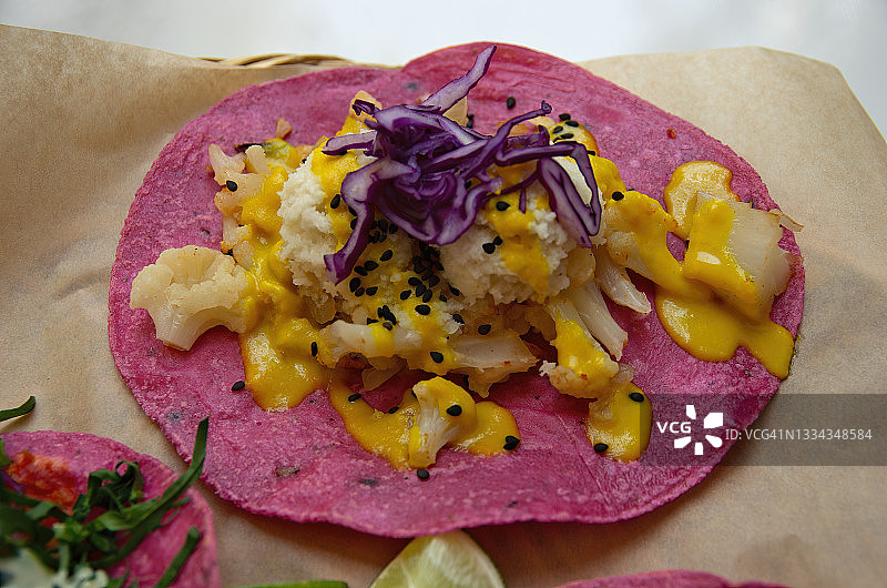 素食coliflor con requesón de coco taco(带有花椰菜，椰子奶酪/凝乳，菠萝奶油，红卷心菜和黑芝麻的玉米卷)图片素材