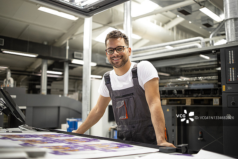 在印刷厂检查印刷质量的控制室工作人员的肖像。图片素材