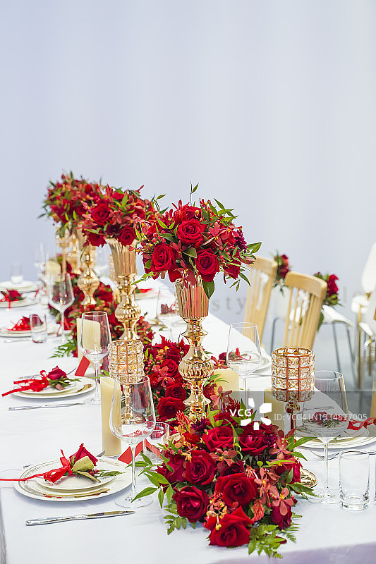 奢华的婚礼装饰与鲜花和玻璃花瓶和许多设置在桌子上图片素材