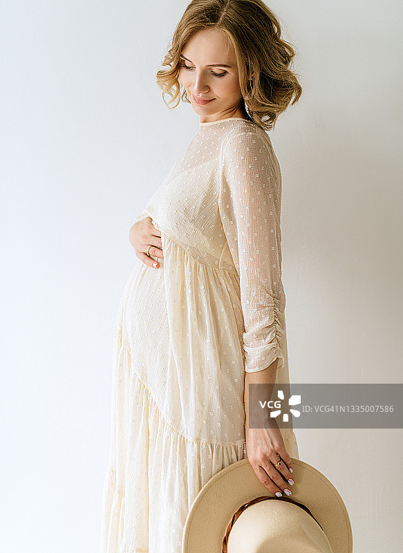 年轻的成年美丽的孕妇等待一个婴儿在产假期间图片素材