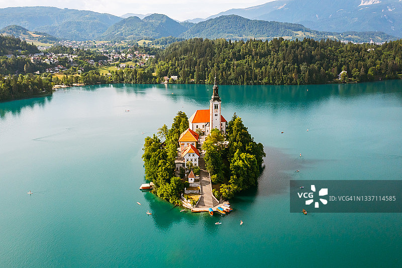 美丽的山湖与蓝绿色的水与小朝圣教堂在朱利安阿尔卑斯的背景上的岛屿。图片素材