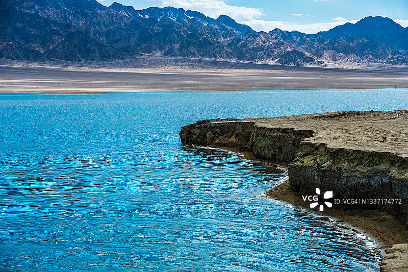 山下的湖被沙漠环绕着。中国新疆维吾尔自治区。图片素材