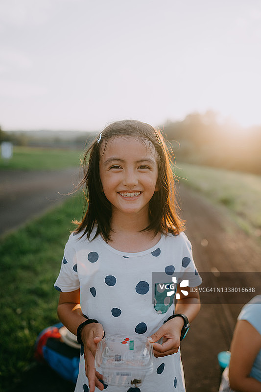 开朗的年轻女孩在日落时对着相机微笑图片素材