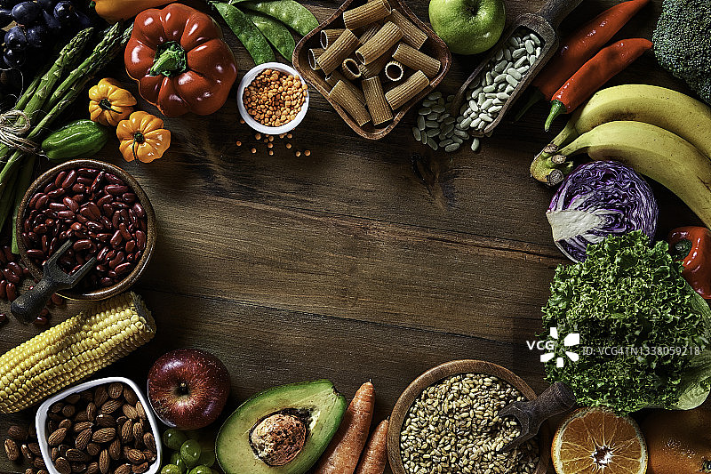在质朴的木桌上膳食纤维新鲜素食和豆类的顶部视图。健康食品主题与框架和复制空间。图片素材
