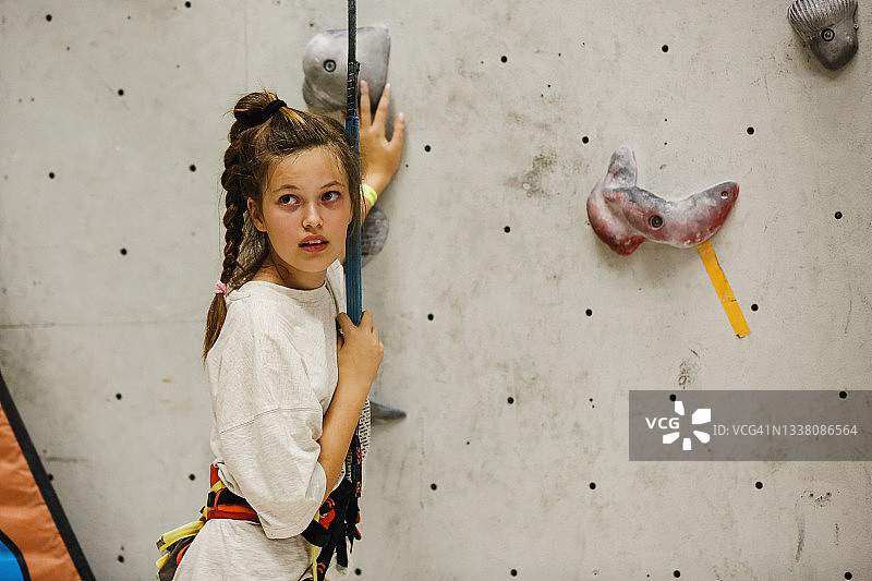 十几岁的女孩在室内攀岩墙健身房训练图片素材