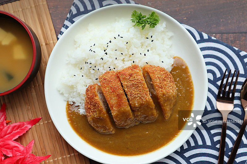 Katsu咖哩——在米饭上煎炸的猪排，上面淋上日本咖哩或Katsu咖哩——日本食物，旁边加味噌汤图片素材