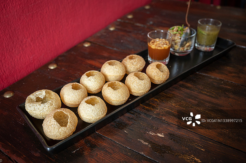 受欢迎的印度食物叫做Pani puri在餐桌上。图片素材