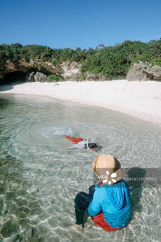 日本冲绳宫古岛，母亲和孩子在享受清澈的热带水域图片素材